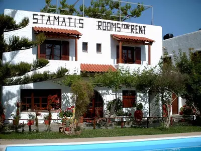 a white building with a sign on the side of it at Summer Lodge in Maleme