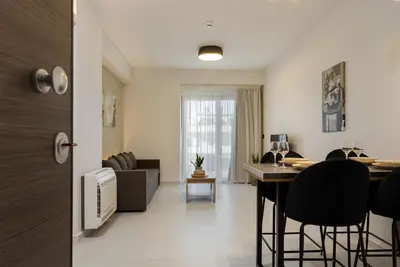 a living room with a table and chairs in a room at Ruby Luxury Suites in Chania Town