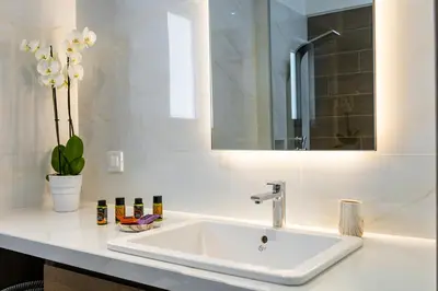 a bathroom with a white sink and a mirror at Ruby Luxury Suites in Chania Town