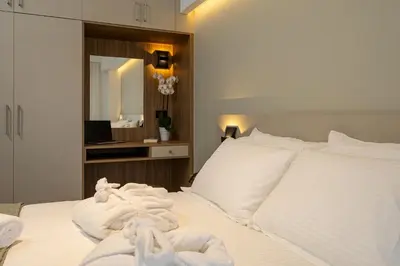a bedroom with white towels on a bed with a mirror at Ruby Luxury Suites in Chania Town