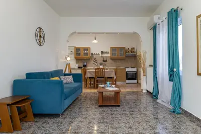 a living room with a blue couch and a table at Vasiliki house in Daratso