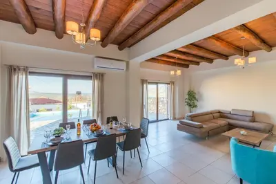 a living room with a table and chairs and a couch at Apokoronas Views Villa in Néon Khoríon