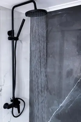 a shower with a stream of water in a bathroom at Nostos Central Apartment in Chania Town