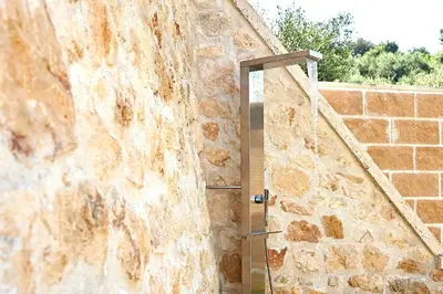 a stone wall with a shower in a room at Sunaktis luxury villa in Chania Town
