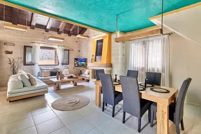 a living room with a table and chairs and a couch at Sunaktis luxury villa in Chania Town