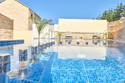 a swimming pool with blue tiles on the water at Sunaktis luxury villa in Chania Town