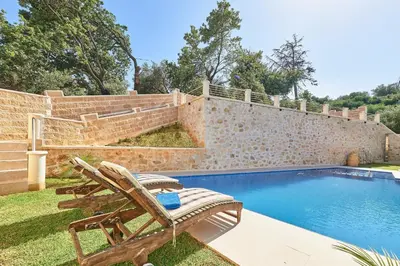 a pool with a bench and a chair next to a wall at Sunaktis luxury villa in Chania Town