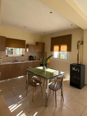 a kitchen with a table and chairs in a room at Koundouros Home in AmigdhalokeFálion