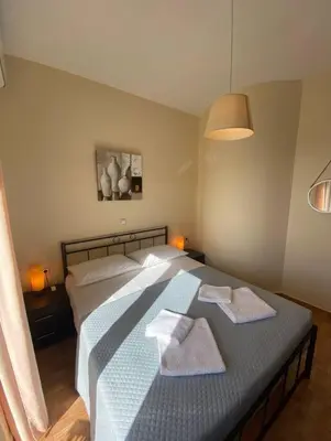 a bedroom with a large bed with towels on it at Koundouros Home in AmigdhalokeFálion