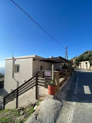 a house with a fence next to a street at Koundouros Home in AmigdhalokeFálion