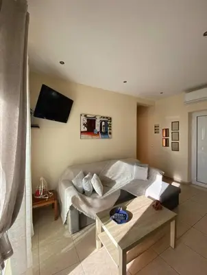 a living room with a couch and a tv at Koundouros Home in AmigdhalokeFálion