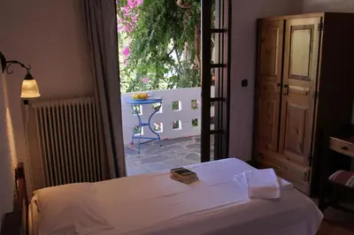 a bedroom with a bed and a large window at Delfini Apartments in Kissamos