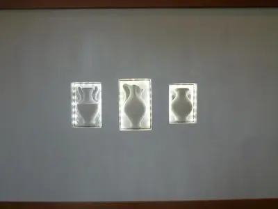 three white vases on display on a wall at Ermis Suites in Plataniás