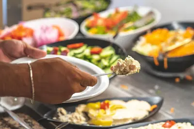 a person eating food on a table with plates of food at Chrispy Waterpark Resort - All inclusive in Kolymvari