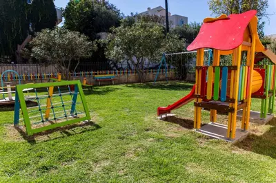 a playground with a slide in the grass at Chrispy Waterpark Resort - All inclusive in Kolymvari