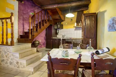 a kitchen with a table with chairs and stairs at Samonas Traditional Villas in Samonás