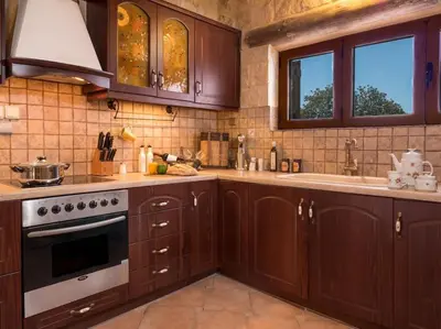 a kitchen with wooden cabinets and a stove top oven at Villa Malaxa Private Luxury with Amazing View in Maláxa