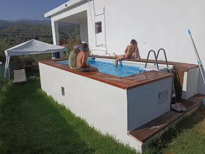 a group of people sitting in a swimming pool at Chania Mini Villas in Skinés
