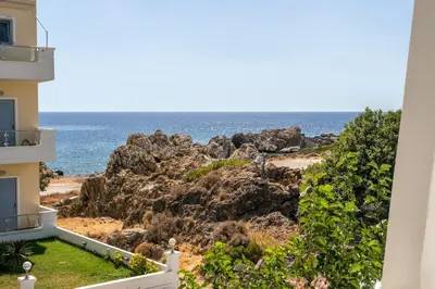 a view of the ocean from the balcony of a building at Aris Boutique Hotel in Palaiochóra