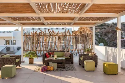a patio with chairs and tables and a chandelier at Aris Boutique Hotel in Palaiochóra