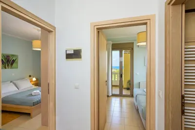 a bedroom with a bed and a view of a room at PanDora maisonette with beautiful gardens and pool in Maleme