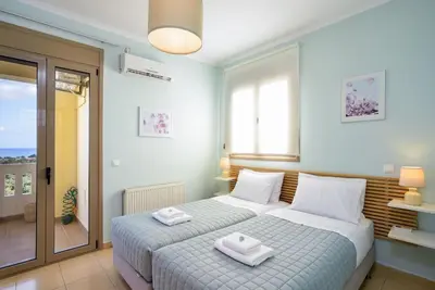 a bedroom with a bed with two towels on it at PanDora maisonette with beautiful gardens and pool in Maleme