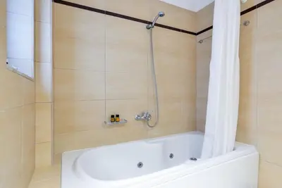 a bathroom with a shower with a bath tub at PanDora maisonette with beautiful gardens and pool in Maleme