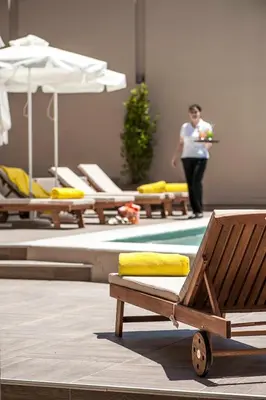 a woman walking in a room with chairs and a table at Kriti Hotel in Chania Town