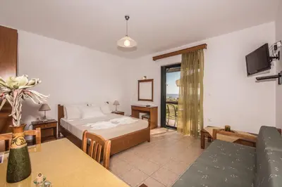 a bedroom with a bed and a living room at Magnolia Apartments and Studios in Falasarna