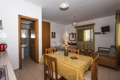 a dining room and living room with a table and chairs at Magnolia Apartments and Studios in Falasarna