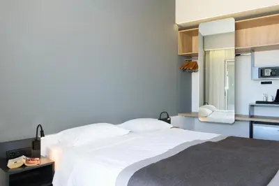 a bedroom with a white bed and a kitchen at Renieris Hotel in Stalos