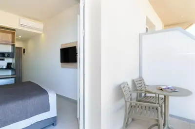 a small bedroom with a small table and a bed at Renieris Hotel in Stalos