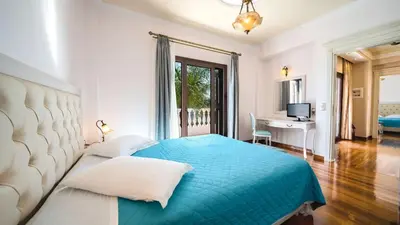 a bedroom with a blue bed and a desk at Iro Royal Villa by PosarelliVillas in Dhémbla