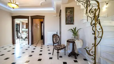 a hallway with a chair and a table and stairs at Iro Royal Villa by PosarelliVillas in Dhémbla