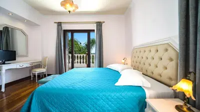 a bedroom with a bed with a blue bedspread at Iro Royal Villa by PosarelliVillas in Dhémbla