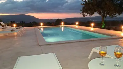 a swimming pool with wine glasses on a patio at Stone villa Halepa panoramic view, private pool,big garden & quiet in Néon Khoríon