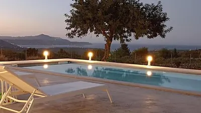 a swimming pool with a chair and a tree at Stone villa Halepa panoramic view, private pool,big garden & quiet in Néon Khoríon