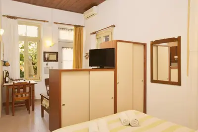 a bedroom with a bed and a tv and a mirror at Silde Studios & Apartments in Chania Town