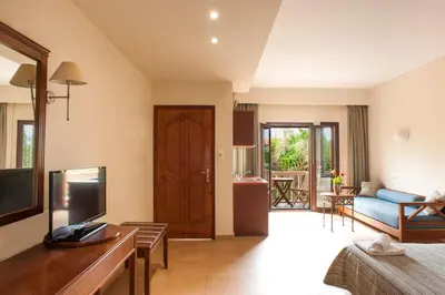 a living room with a couch and a television in a room at Frideriki Studios & Apartments in Plataniás