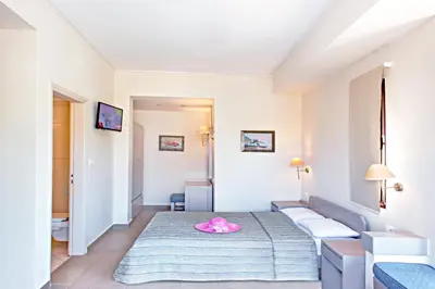 a room with a bed with a pink hat on it at Frideriki Studios & Apartments in Plataniás