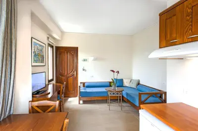 a living room with a blue couch and a table at Frideriki Studios & Apartments in Plataniás