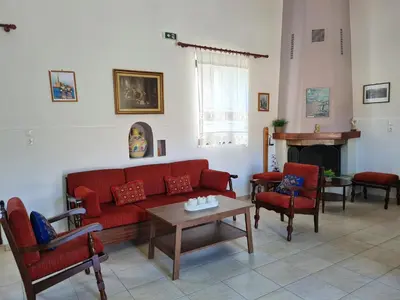 a living room with a red couch and chairs at Enastron vacation house in Kissamos