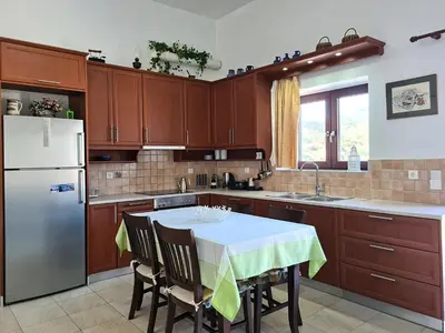 a kitchen with a table and a refrigerator at Enastron vacation house in Kissamos