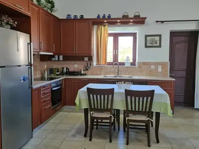 a kitchen with a table with chairs and a refrigerator at Enastron vacation house in Kissamos