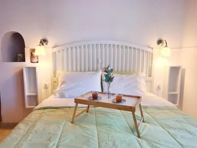 a bedroom with a bed with a table with flowers on it at Enastron vacation house in Kissamos