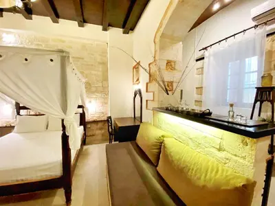 a bedroom with a bed and a couch and a window at Boutique Hotel Del Doge in Chania Town