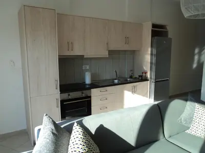 a kitchen with wooden cabinets and a couch in a room at The Getaway in Agia Marina Nea Kydonias