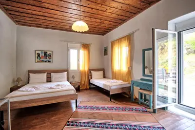 a bedroom with two beds and a window at Aretousa by PosarelliVillas in Dhrakóna