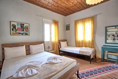 a bedroom with two beds and a fireplace in it at Aretousa by PosarelliVillas in Dhrakóna