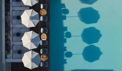 an overhead view of a pool with white umbrellas at Asterion Suites & Spa - Designed for Adults in Gerani Chanion
